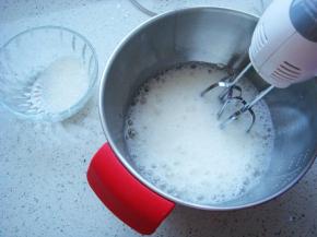 蛋白里挤入柠檬汁，白砂糖分三次加入高速打发蛋白。