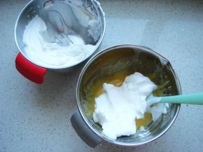 把打好的蛋白分一半倒入蛋黄糊糊里。呈“J”字形翻拌，不可划圈避免消泡。