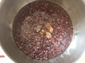 煮好的红豆取出，倒入小锅内，加200克的水跟30克黄冰糖，小火加热至黄冰糖融化。