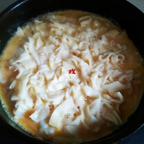 平底锅中放黄油，放手擀面再淋入打散调入盐的蛋液，小火煎