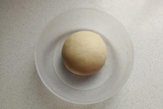 然后开始揉面，揉面至粗膜状态后加入软化的黄油继续揉面，揉至扩展阶段后把它揉成光滑的面团，放入容器中盖上保鲜膜发酵。