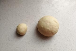 把发好的面团取出来挤压揉搓排气，然后分出一份重约40克的小面团。