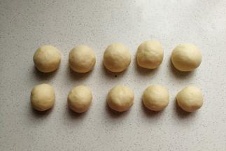 再把这五个小面团各自分成两份搓圆盖上保鲜膜醒发（其中一份面团比另一份重5克左右）