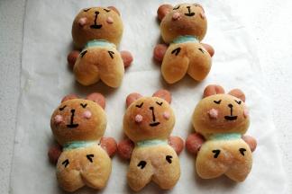 接下来融化一点白巧克力装入裱花袋，在脖子处挤上一条巧克力当围脖，然后在小脸蛋上挤上两个小圆点当q萌腮红，趁着巧克力没凝固前，迅速撒上彩色砂糖装饰即可。