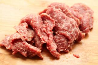 牛肩肉逆着纹理切成薄片。牛肉切的时候逆着纹理切，这样煎出来会比较嫩。