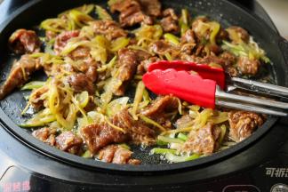 电饼铛继续工作，倒入一些花生油，油热之后放入刚才腌好的牛肉，煎至变色就可以了。牛肉片很嫩很滑。