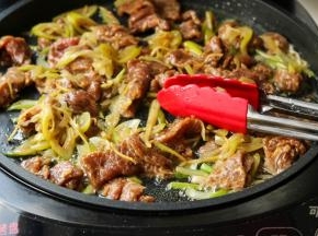 电饼铛继续工作，倒入一些花生油，油热之后放入刚才腌好的牛肉，煎至变色就可以了。牛肉片很嫩很滑。