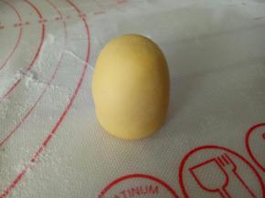 12克黄色面团滚圆，双手搓成圆柱状，作为狮子的身体