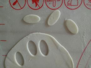 一小块白色面团擀薄片，用椭圆形模具压几片椭圆形作为狮子的白肚皮，（没有模具可以先搓一个椭圆形然后在压扁）