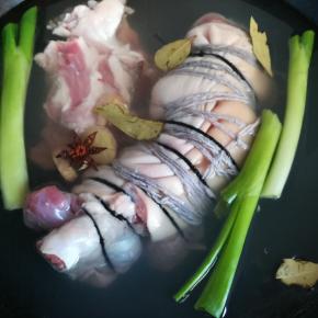 用棉线将肘子绑上，放入已下葱姜八角香叶的锅中进行焯水。