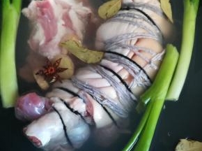用棉线将肘子绑上，放入已下葱姜八角香叶的锅中进行焯水。