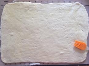 发酵好的面团排气松弛15分钟后，擀成长方形，刷上玉米油