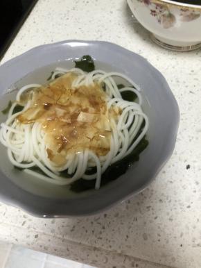 9. 加入冒好的米粉，撒上适量的木鱼花和葱花即可。