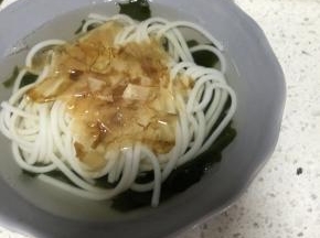 9. 加入冒好的米粉，撒上适量的木鱼花和葱花即可。