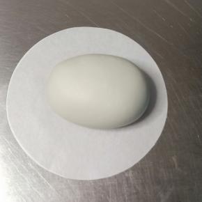 4个40克的面团揉搓排气滚圆，搓成鸡蛋状稍按扁，横着放