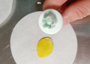 黄色面团擀厚片，用小花压模压出花朵