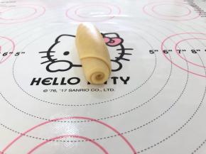 8、自下而上卷起，继续盖上保鲜膜松弛15分钟。