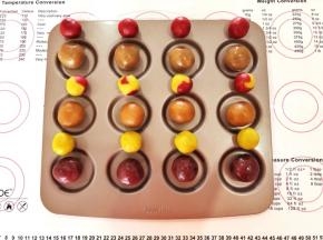 3、按照桃山皮每个15克，月饼馅每个35克，各自称量出12份，每个口味的月饼馅4份对应一种口味的桃山皮(自由搭配），中间一排的彩色桃山皮是用两种口味的桃山皮随意组合后揉在一起的。