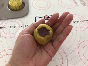 6、虎口向上慢慢收拢，让桃山皮均匀的裹住香芋馅。