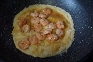 鸡蛋煎至6成熟倒入虾仁