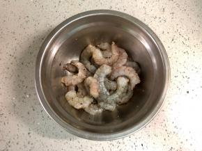 虾仁自然解冻后，洗净，用厨房纸吸干水分，然后放一勺料酒去腥，磨入黑胡椒颗粒，抓匀后腌制半小时以上。