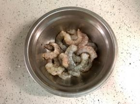 虾仁自然解冻后，洗净，用厨房纸吸干水分，然后放一勺料酒去腥，磨入黑胡椒颗粒，抓匀后腌制半小时以上。