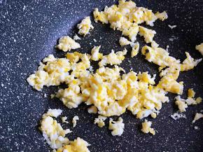 不用加油，用锅中底油把鸡蛋炒散，盛在米饭上