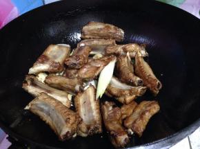倒入排骨炒匀，烹黄酒去腥