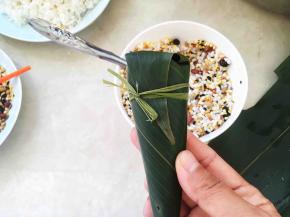 系上棕线条，锥形粽子就包好啦，包裹的时候不要裹的太严，不漏出米就行，太紧煮的时候米膨胀，会撑破粽叶的