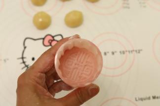 放少许的玉米淀粉到月饼膜内，均匀粘满后倒掉多余的面粉