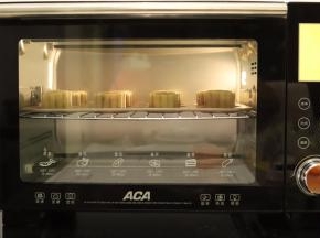 ACA HC27HT烤箱设置烘烤功能，温度为200度，预热后放入月饼，中层烤5分钟