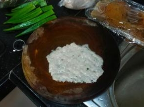 砧板、手上粘点水，将鱼滑平铺在砧板上