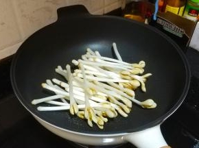 锅里热油放盐、花生芽翻炒至熟