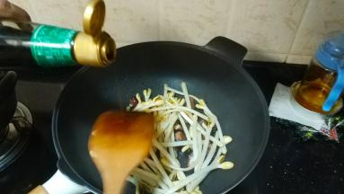 倒入花生芽、酱油、糖