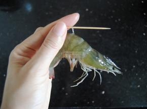 从虾颈数下来第三个关节，用根牙签从这里插入，把虾肠提起拉出丢弃，虾就处理干净了。