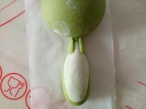 搓两个小小的圆柱稍稍按扁粘到身体上部，作恐龙的手臂