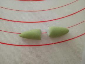 再取大一点点的绿色面团搓成梭状，中间切开