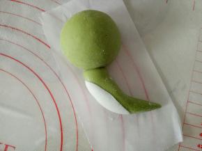 10克的面团搓成一边尖一边粗的椭圆状，尖头朝下，粘到头部，把尾部稍微往一边弯一下，白色面团搓椭圆擀薄片贴身体上作为小恐龙的肚皮，贴侧面哦，我们做的是侧面的恐龙