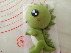 一点点白色面团揉一点点红曲粉作红色面团，把腮红粘上，黑色面团搓细条做嘴巴，再用白色面团做一颗小小的牙齿