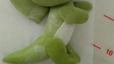 取一个比刚才稍大一点的面团捏出上侧的腿来，下面微弯一下，更形象一点