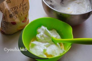 用刮刀取出1/3的蛋白霜至蛋黄糊中，上下翻拌均匀