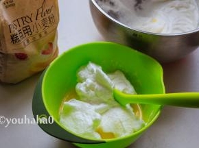 用刮刀取出1/3的蛋白霜至蛋黄糊中，上下翻拌均匀