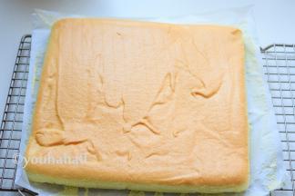 烤盘在台面上震动几下，震出面糊里的大气泡，将烤盘放入已预热到150度的烤箱中下层，烘烤25分钟。到时立刻取出，倒扣在铺好油纸的网架上，迅速撕掉油纸，再次翻面放凉。