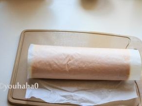 蛋糕卷用正面、反面都可以，反面撕油纸的时候，不小心撕破了相，直接将淡奶油涂抹在上面，借助油纸和擀面杖卷起蛋糕，放入冰箱冷藏一个小时以上。