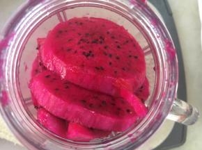 将裁下来的火龙果边角跟剩下的火龙果装入到榨汁机内