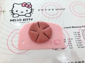 16、收口向下用手轻轻按扁，用小刀划出五个花瓣的部分，注意留在出花心部分，割出花蕊。