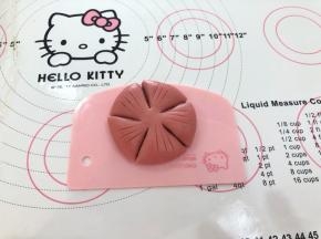 16、收口向下用手轻轻按扁，用小刀划出五个花瓣的部分，注意留在出花心部分，割出花蕊。