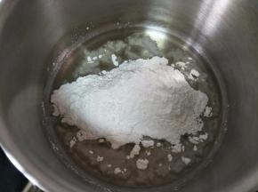 奶锅中倒入玉米油，小火加热到出现细小纹路，关火倒入低筋面粉，搅拌顺滑。