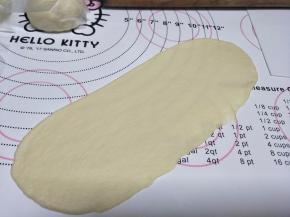 用擀面杖擀开牛舌状。注意一定要把面里的空气排干净，否则炸制的时候容易气泡。