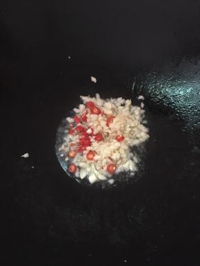 锅里放油，爆香辣椒和蒜